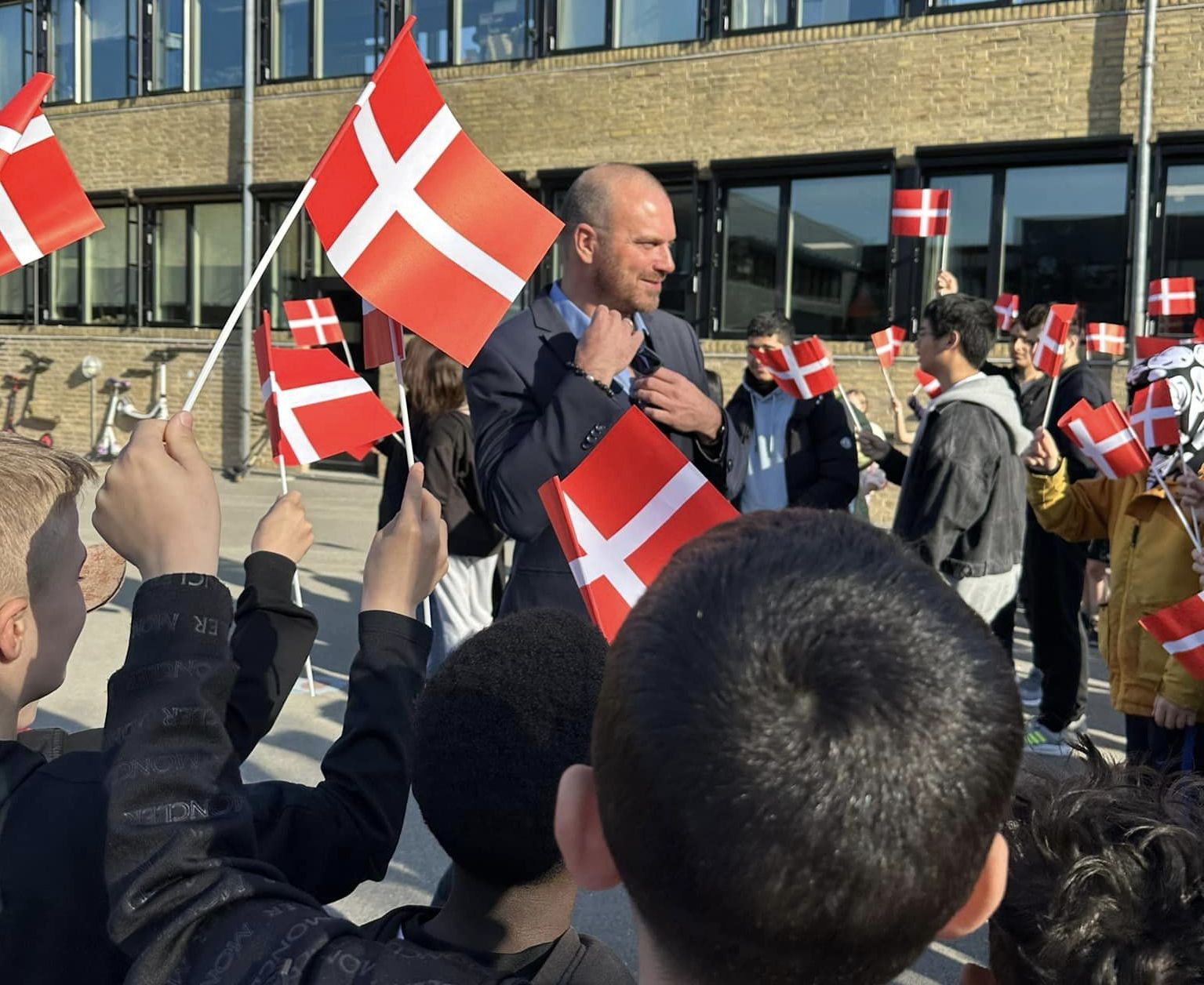 Skoleleder Morten Pejter Roitmann fra Gungehusskolens første arbejdsdag fejret af elever med flag